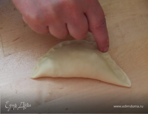 На одну половину круга положить фарш, размазать его, накрыть фарш другой половиной круга и тщательно защипать. 