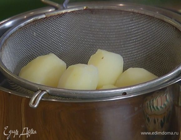 Отваренный картофель почистить и выложить в посуду, в которой вы будете его подавать на стол. Прикрыть крышкой, чтобы он не остыл.