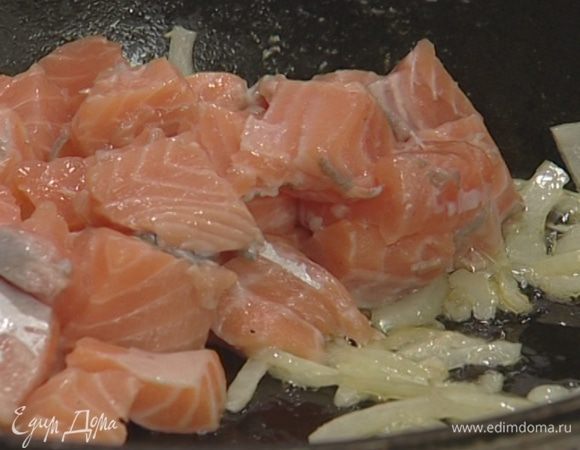 Рыбу нарезать небольшими кубиками (1−1,5 см), выложить в сковороду к луку и жарить пару минут на небольшом огне.