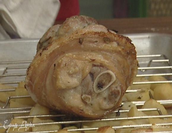 Отваренную картошку посолить, посыпать черным перцем, выложить на противень, находящийся в духовке, и равномерно распределить. Запекать картошку и рульку еще 30 минут.