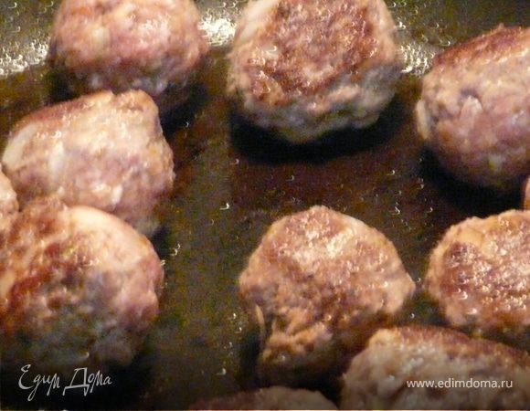 В ту же сковороду положить лук, чеснок, травы и специи, затем всыпать рис, вино и залить бульоном, протушить ок. 10 минут, добавить фасоль и тефтели и тушить до готовности риса (еще минут 10).
