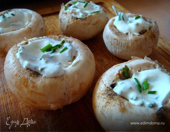 Духовку разогреть до 220-240 гр.Ц. Подготовить решетку- смазать растительным маслом. На противень, который будет расположен под решеткой добавить воды, чтоб жир с голяшек стекал туда.
Теперь комплимент: шампиньоны вымыть, обсушить или просто почистить- удалить ножки (так,чтоб осталось углубление). Лук резанец мелко нарезать и смешать со сметаной. Грибы присолить и начинить нашей сметанной начинкой