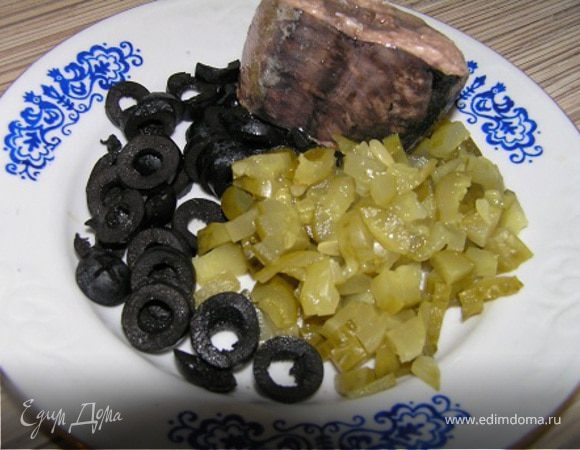 Нарезать огурчики и маслины.