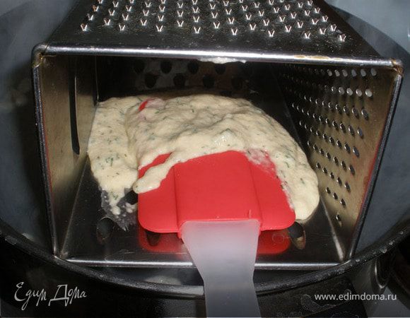 Вода уже должна закипеть к этому моменту. Выкладываем частями тесто и продавливаем лопаткой через терку. 