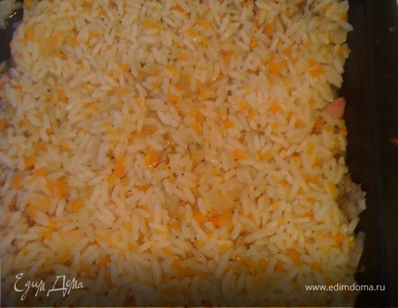 Половину готового риса выкладываем в противень, смазанный оливковым маслом.