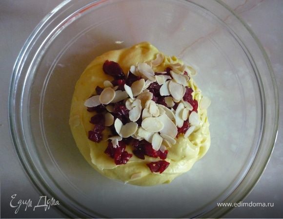 Масло комнатной температуры смешать с сахаром чтобы увеличилось в объеме, добавить по одному яйцу, хорошо взбить,затем муку,цедру. Вмешать в готовое тесто вишню порезаную мелким кубиком и хлопья миндаля. Выложить в формы не полные и выпекать на 180С 15-20мин.