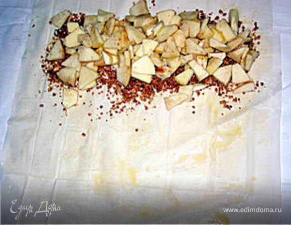 сверху выкладываем рублённые очищенные яблоки, посыпаем орехами, шоколадом, изюмом, сверху посыпаем сахаром с корицей.