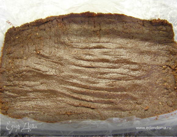 Форму выстелить бумагой или пищевой плёнкой. Утрамбовать по дну шоколадную крошку.