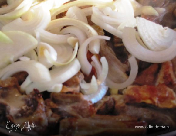 Жарить ребрышки 10-15 минут, добавить резанный полукольцами лук. Перемешать.