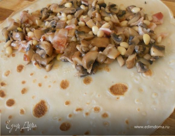 На блинчик выложить начинку, свернуть рулетом.