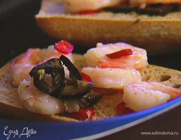 Хлеб перевернуть поджаренной стороной вниз, выложить на него креветки с маринадом и сбрызнуть оливковым маслом.