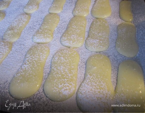 Сделать корнетик.
Протвень покрыть пергаментной бумагой.
Выдавить длинные полосочки.
Притрусить сахарной пудрой.