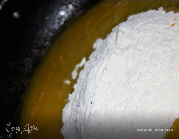 Когда масло полностью растопится, добавить муку, хорошо перемешать. 
Слегка обжарить