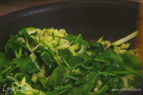 В сковороду, где жарился бекон, выложить цукини и шпинат и, непрерывно помешивая, обжаривать, пока шпинат не станет мягким.