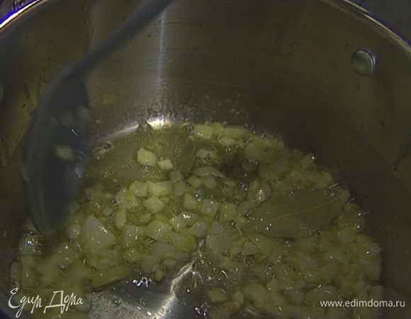 В глубокой кастрюле с тяжелым дном разогреть 1 ст. ложку оливкового масла и сливочное масло, отправить туда лук и чеснок и на медленном огне довести до прозрачности. Добавить лавровый лист.