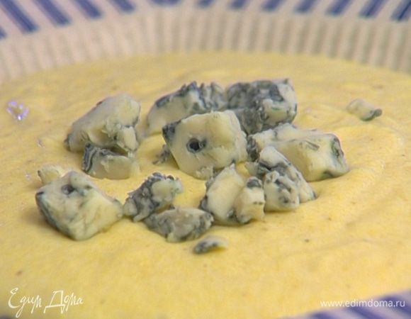 Выложить поленту на тарелку, сверху разложить нарезанную горгонзолу, присыпать листьями базилика.