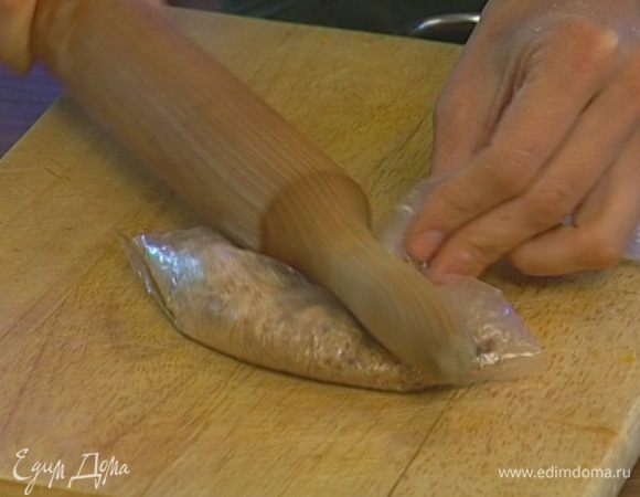 Печенье положить в пакет и измельчить скалкой.