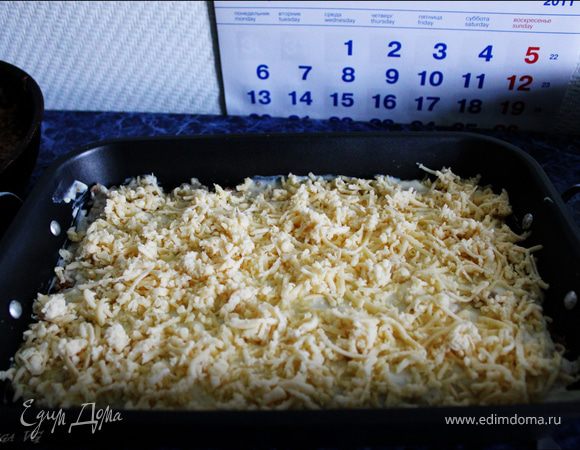 Посыпать половиной натертого сыра.