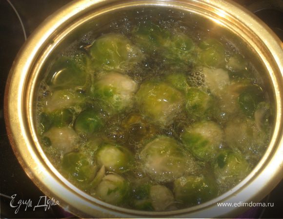 Брюссельскую капусту кинуть в кипящую,подсоленную воду и варить 7-8 минут. Вынуть и охладить в ледяной воде. А затем нарезать каждый кочан на пополам.