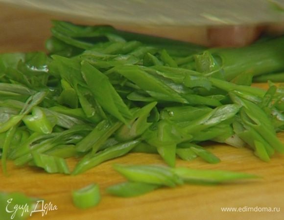 Зеленый лук нарезать наискосок и половину добавить к руколе.