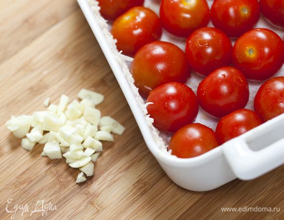 Выложить в форму помидоры и нарезанный чеснок, немного посолить и поперчить, сбрызнуть оливковым маслом.