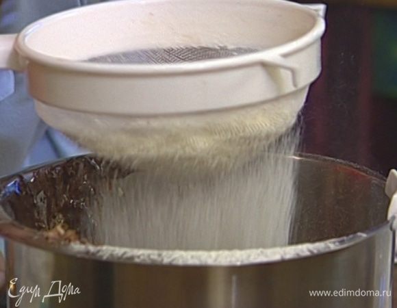 В масляно-яичную массу всыпать просеянное какао, затем частями ввести просеянную муку с содой. 