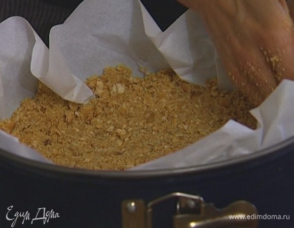 Застелить разъемную форму бумагой для выпечки, выложить в нее получившееся тесто, распределить и плотно утрамбовать так, чтобы получились стенки (чем меньше диаметр формы, тем выше будет торт). Поставить в морозилку минимум на 30 минут. 