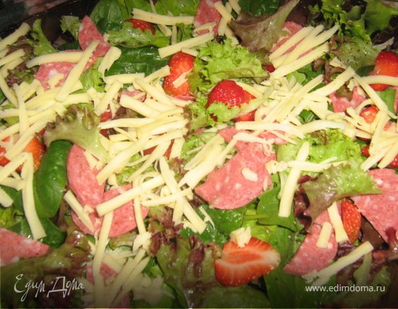 Салями нарезать тонкими ломтиками. Сыр крупно натереть. Клубнику вымыть, высушить, нарезать пластинками. Выложить все на салат.