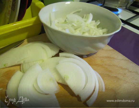Луковицу почистить, нарезать тонкими полукольцами. Выложить в глубокую мисочку, залить кипятком и оставить остывать. Когда вода станет теплой (минут через 15), отжать от нее лук. В той же мисочке сбрызнуть лук уксусом и оставить мариноваться, пока вы режете все остальное
