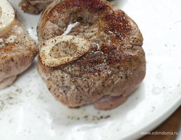 В тяжелой форме для запекания разогреть оливковое масло и обжарить мясо с обеих сторон до золотистого цвета. Выложить мясо на блюдо, посолить и поперчить его.