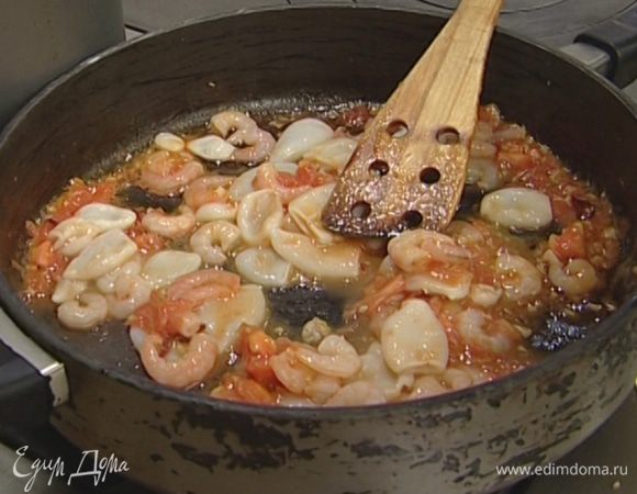 Кальмаров нарезать кольцами, а креветки и рыбу — небольшими кусочками и добавить в сковороду.