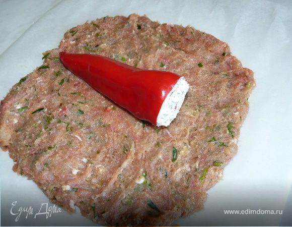 На рабочую поверхность выложить мясную массу слоем 1см, посредине положить перец, фаршированный брынзой. Сформировать рулет.