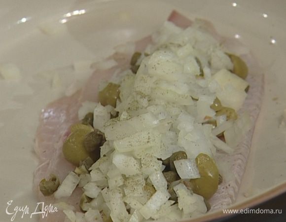 В жароупорную посуду уложить 2 филе рыбы, сверху — лук с оливками, каперсами и чесноком, посолить.