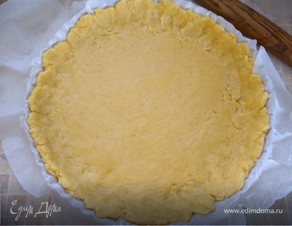 Перенести тесто вместе с бумагой в форму и подправить края, делая бортик.