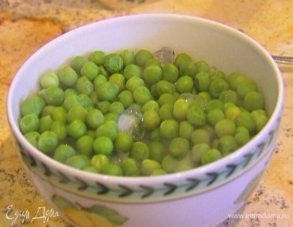 Зеленый горошек залить кипятком и варить несколько минут на небольшом огне, затем воду слить, а горошек отправить в миску со льдом.