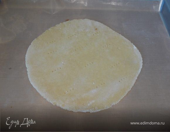 Разогреваем духовку до 180 градусов, раскатываем каждую порцию теста в тонкий круглый корж. Я раскатывала на столе и переносила на коврик для выпечки, не смазывая его уже ничем. Можно раскатать сразу на пергаменте или смазанном маслом (немного) протвине. При раскатывании тесто немного обваливаем в муке, чтобы не прилипло к столу (у него получается довольно легко рвущаяся консистенция). Перед выпечкой корж наколоть вилкой в нескольких местах. 