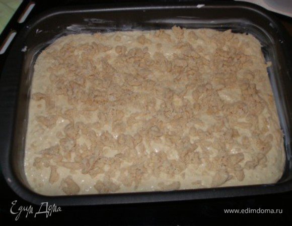 Форму смазать маслом, выложить тесто, сверху - посыпка. 