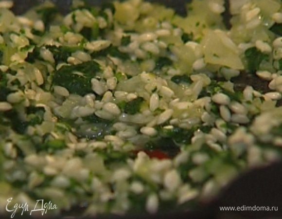 Когда лук станет мягким, добавить нарезанную крапиву, перемешать и всыпать рис. Непрерывно помешивая, прогреть рис с крапивой, затем влить вино. 