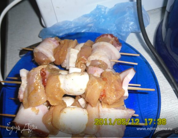 Режем шампиньоны четвертинками,грудинку тонкими полосками.

Достаем мясо и нанизываем его на шпажки вместе с шампиньонами.При этом курицу мы заворачиваем в полоски грудинки.