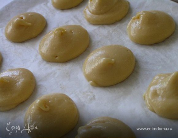 Заполнить заварным тестом кондитерский шприц с круглой насадкой и отсадить на выстеленный бумагой для выпечки противень 20-24 шарика одинакового размера.