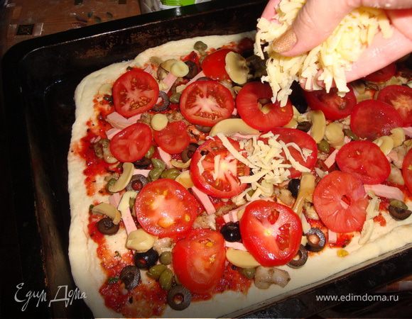 тесто наше подошло, достаем его из посуды, делим на несколько частей, в зависимости от того какой величины вы хотите вашу пиццу, я разделила на 3 части и было у меня 3 огромные пиццы. раскатываем, обмазываем нашим соусом, выкладываем начинку в любой последовательности, посыпаем сыром и в разогретую духовку на 20-25 минут.