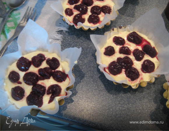 Формочки (у меня диаметром 10,5 см)выстилаем бумагой для выпечки и наполняем на 3/4 нашим тестом.Сверху выкладываем вишни.Выпекаем чизкейки около 20-25 минут при температуре 200 градусов.