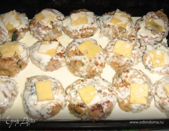 Выложить тефтели на смазанный маслом противень. Сыр нарезать тонкими ломтиками по размеру тефтели. Смешать йогурт и сливки, добавить специи. Залить соусом тефтели.