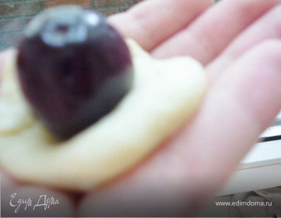 Руками слепить круглую лепёшку(не очень тонко),вложить ягоду черешни и скрепить края вместе.(можно ставить по 2-3 ягоды)
