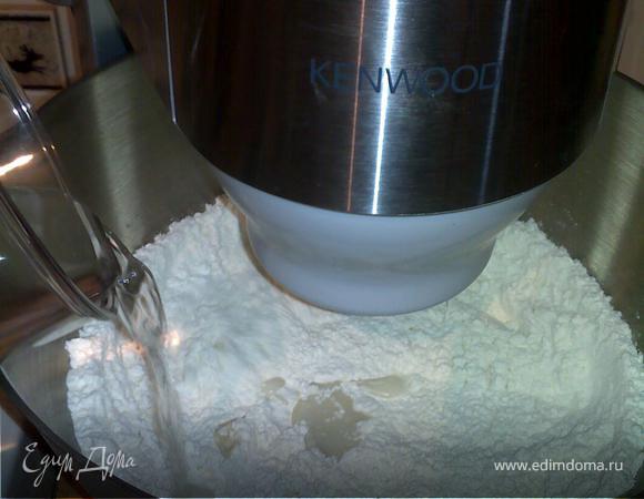 4. ввести воду и перемешивать еще 2 минуты. Затем увеличить скорость и месить еще 6-7 минут, пока тесто не станет эластичным.