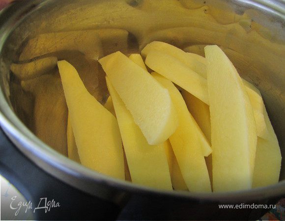 Картошку вымыть, почистить, нарезать длинными брусочками, оставить в холодной воде полежать минут 10. Включить духовку разогреваться на 220 градусов.