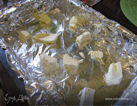 В форму выложить кусочки сливочного масла. У меня форма старенькая, страшненькая, я ее, бедолагу, застелила фольгой. Вы можете не заморачиваться)