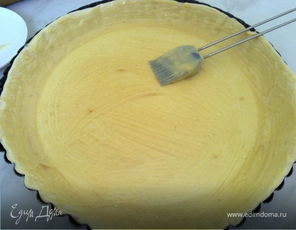 Смазываем форму для запекания маслом и выкладываем слоеное тесто. Накалываем его вилкой, и распределяем миндальный крем слоем примерно пару миллиметров.

