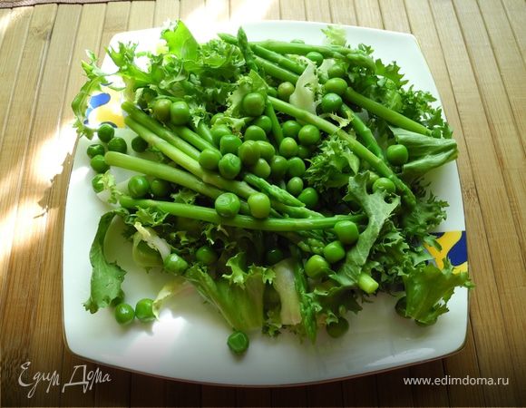 Раскладываем на тарелке салат фризе. Добавляем спаржу и зеленый горошек.
