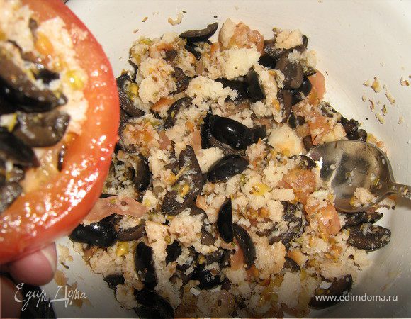 Мелко порезать мякоть и смешать с хлебными крошками,добавить приправы и раздавленный зубчик чеснока,маслины порезать на четвертинки,добавить к крошкам и мякоти помидор,приправить
